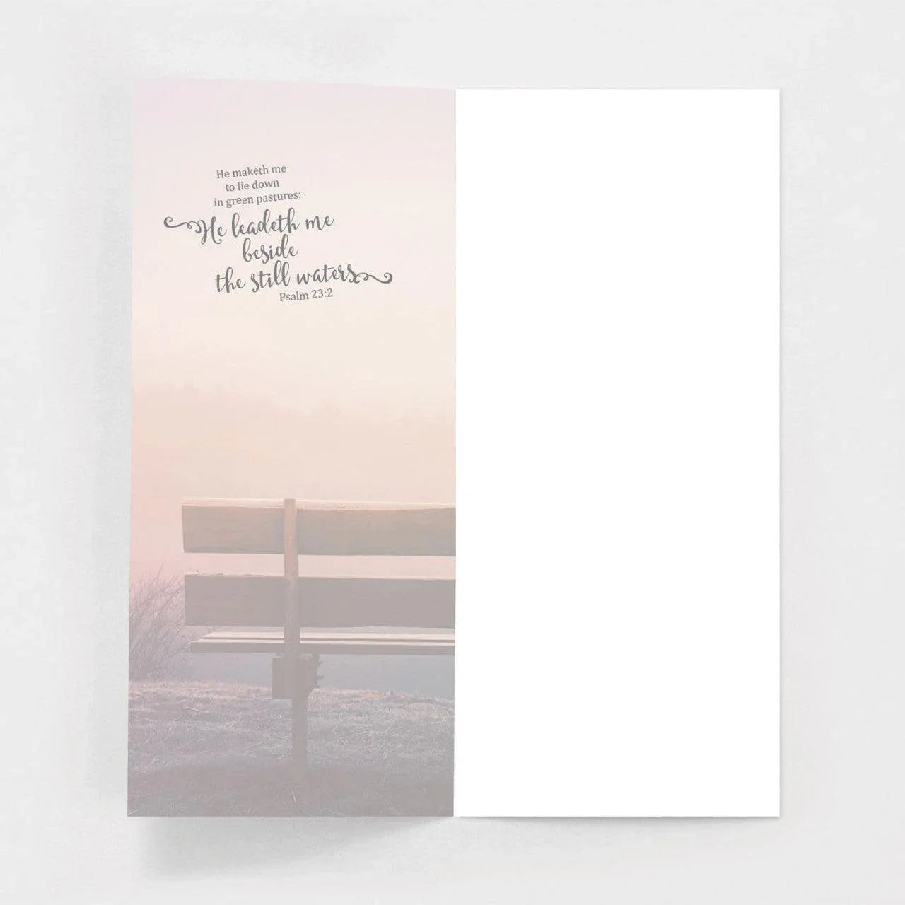 Inspirational blank greeting card with Psalm 23:2, bench, and serene misty background.