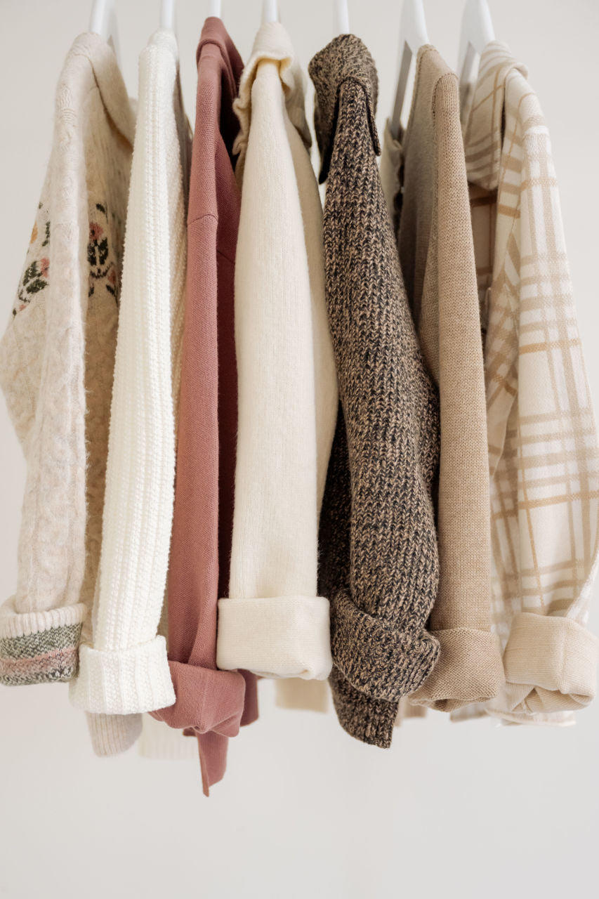 Neutral toned modest women's sweaters hanging on white rack, Salt and Honey boutique