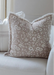 Floral patterned pillow on a white sofa with a neutral background