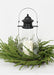 Decorative lantern with a candle surrounded by greenery on a white background