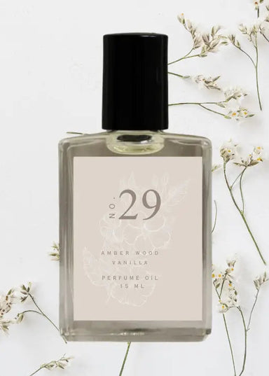 Perfume oil bottle labeled 'No. 29' with a black cap on a light background with floral elements.