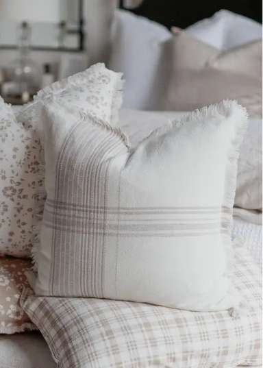 Decorative pillows with floral and plaid patterns on a sofa.