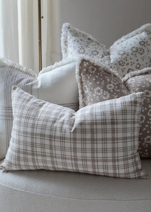 Decorative pillows on a sofa with floral and plaid patterns