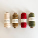 Four spools of thread in different colors on a white background