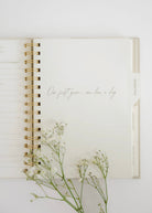 Open notebook with floral branch on a white background