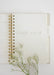 Open notebook with floral branch on a white background