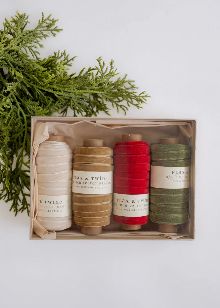 Set of spools of thread in various colors with a wooden box on a white background