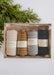 Set of yarn spools in a box with greenery on a white background
