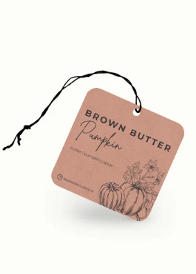 A square kraft paper spice tag for 'Brown Butter Pumpkin' with a black hanging string, featuring a pumpkin illustration and text, shown on a clean white background.