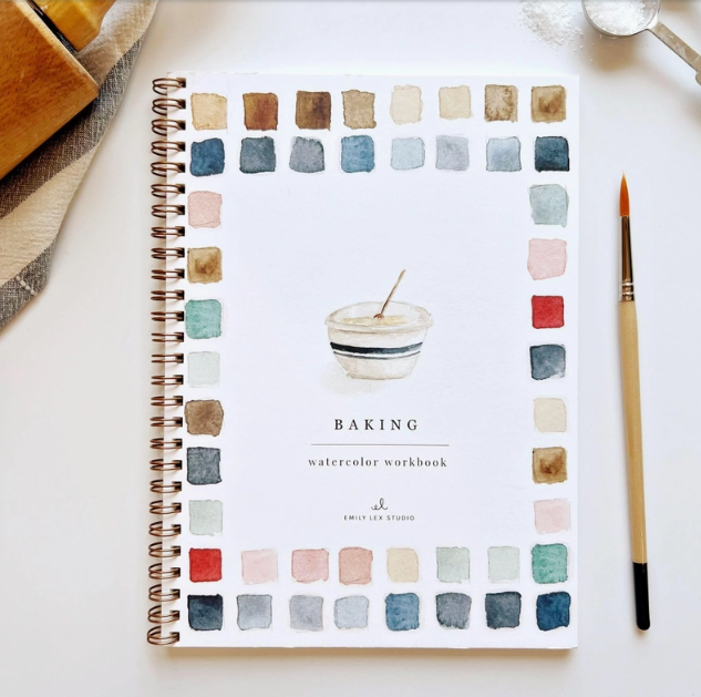 Spiral-bound watercolor workbook titled 'Baking' with color swatches on a white surface.