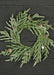 Green artificial wreath with pinecones on a dark wooden background