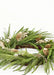 Green Christmas wreath with gold pinecones and white berries on a white background