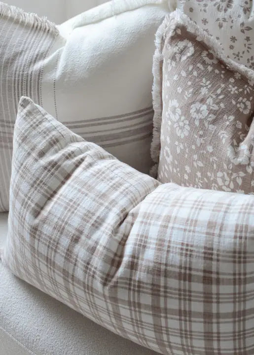 Brown and White Plaid Patterned pillows on a sofa with a neutral color scheme