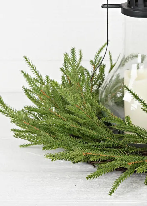 Decorative lantern with candle and greenery on a white background