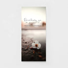 Sympathy greeting card with white flower on wet ground and 'Remembering you in prayer' text.